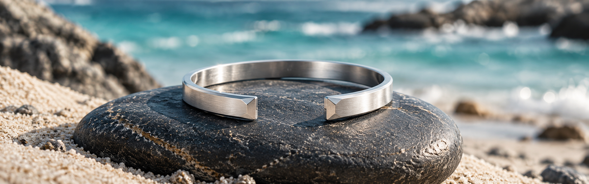 Silver cuff bracelet beside the ocean